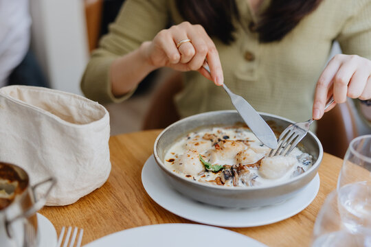 Woman dining on creamy scallop dish