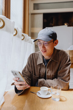 Man enjoying coffee while using smartphone