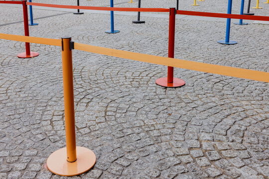 Colorful queue barriers on cobblestone ground