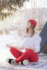 Serene young woman meditating in lotus position amidst a peaceful snowy forest, practicing mindfulness and finding zen during a winter retreat.