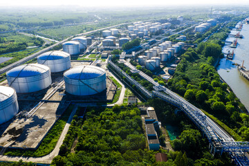 large oil storage tanks and pipelines near river port