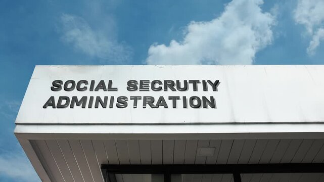 Social Security Administration word sign displayed on building facade under clear blue sky, representing public welfare, retirement services, and government-managed social insurance programs.