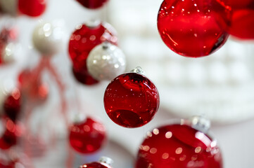 Shiny red and white glass baubles hanging as Christmas decoration