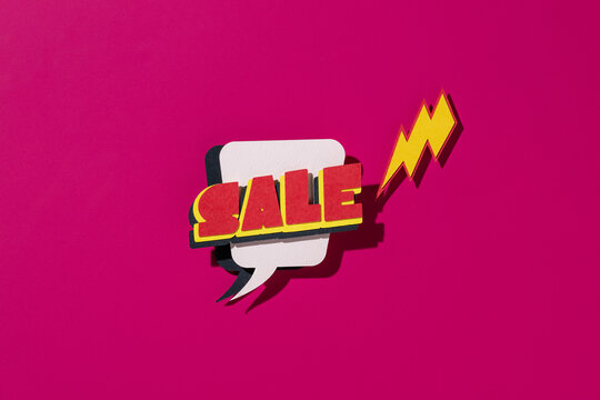 A vibrant pop art sale sign with a lightning bolt on pink background