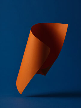 An abstract studio shot of orange paper with blue background.