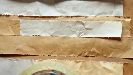 Close-up of various torn paper strips and masking tape, creating a textured background. - Powered by Adobe