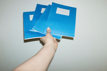 Hand holding blue classic school education notebooks with flashlight