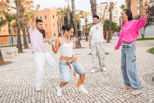 Group of friends dancing outdoors in city park