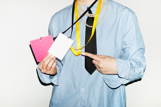 Person wearing suit & tie and holding business conference event badge