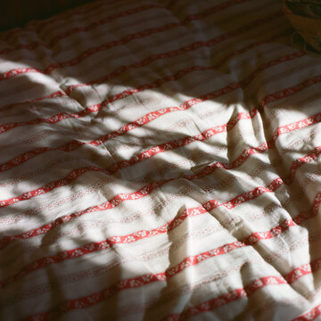 Sunlight flares over bed sheets