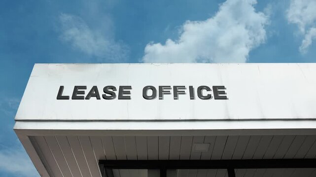 Lease Office word sign displayed on building facade under clear blue sky, representing property rental services, tenant agreements, and real estate management administration.