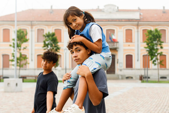 Siblings Enjoying Time Together in a European Town Square