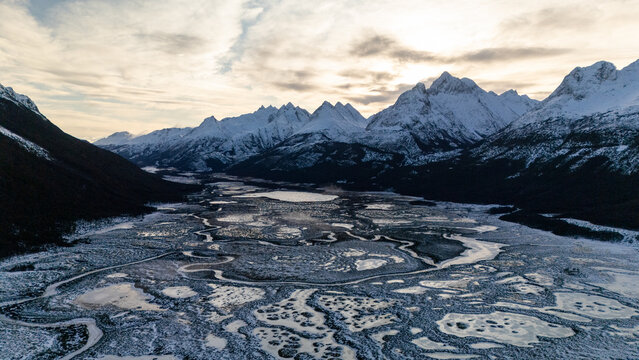 Breathtaking Aerial View of Snow-Covered Mountains and Wetlands
