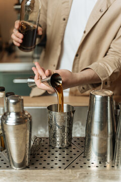 Bartender pouring liquor into cocktail shaker