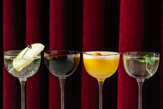 Assorted cocktails in coupe glasses with garnishes