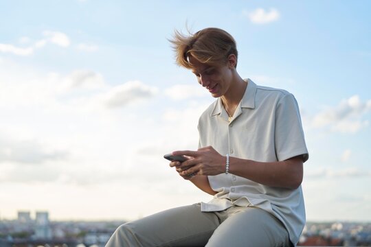 Young Person Enjoying Time on Rooftop While Using Smartphone