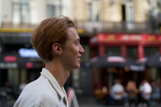 Young Man Walking Happily Through a Bustling Urban Street