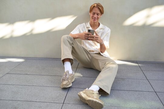 Young Man Enjoys Casual Moments While Texting Outdoors