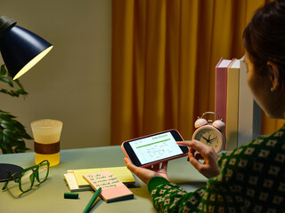 A woman reviews her daily schedule on her phone while working