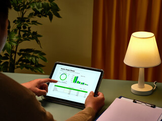 Someone reviews a financial budget planner displayed on digital tablet