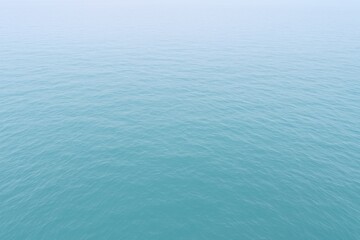 Obraz premium Calm ocean surface with soft ripples, creating a serene, minimal, and tranquil blue seascape background