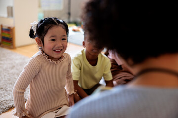 Children interacting with an adult in a bright room.