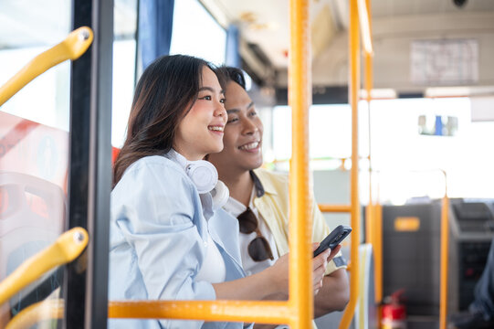 Asian tourist couple go on trip woman holding phone man looking ahead while sitting in shuttle bus. - Powered by Adobe