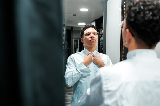 Customer buttoning shirt collar in mirror reflection
