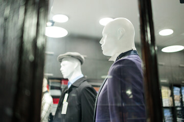 Mannequins dressed in formalwear behind store window