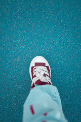 Foot in a Sneaker on a Blue Textured Ground