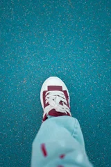 Foot in a Sneaker on a Blue Textured Ground © fandijki