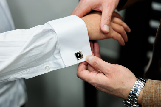 Vendor helping customer with cufflinks detail