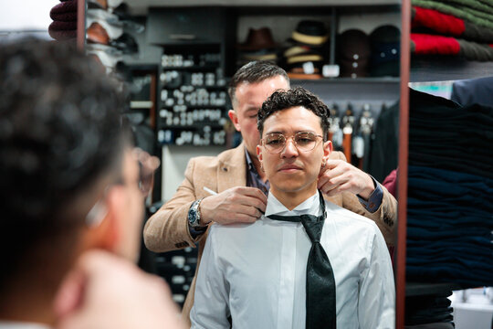 Customer Fitting Bow Tie with Assistance in Menswear Store