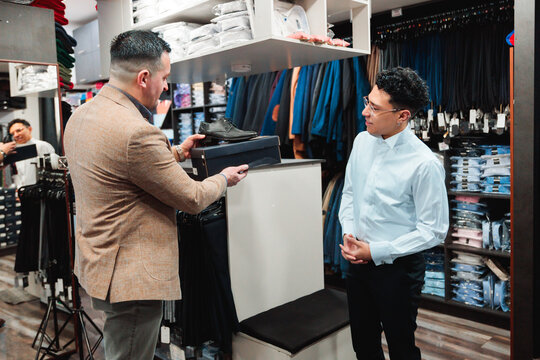 Vendor presenting shoes to customer during fitting