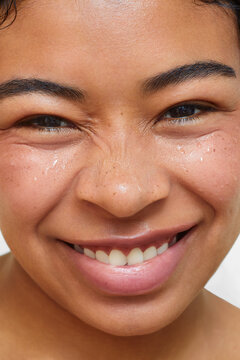 Close-up of Latina woman smiling with eyes squinting 