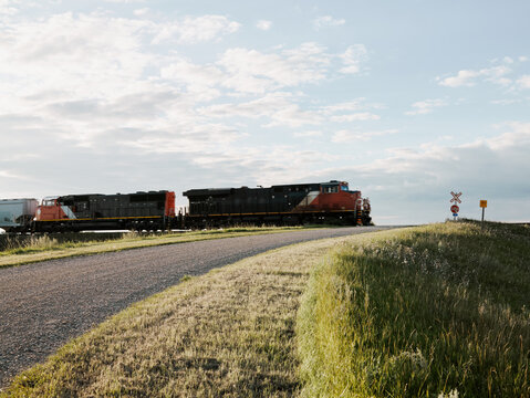 Freight train locomotive crossing rural railway road