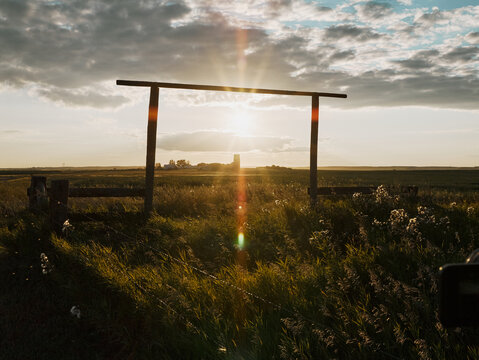 Sunset over prairie gate with dramatic clouds