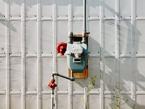 Natural gas meter and pipes on industrial wall