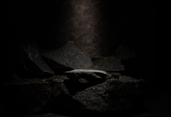 A still life composition of natural stones for the presentation of medical products, cosmetics, makeup, perfumes, and jewelry. A podium with a dark background and textured stones.