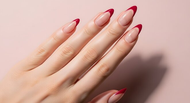 Elegant french manicure with red tips on delicate hands