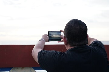 A man takes a beautiful photo of the sky with his smartphone