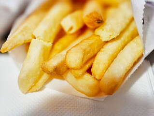 Crispy golden fries served in a paper wrapper at a fast food restaurant during lunchtime