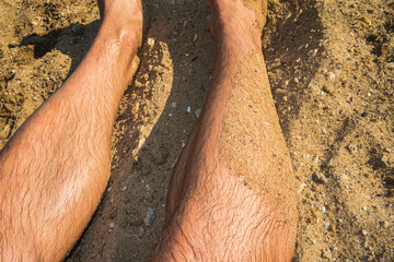 Legs Covered in Sand During a Sunny Beach Day
