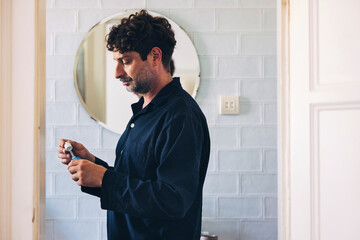 Man Preparing Skincare Items in a Modern Bathroom Setting