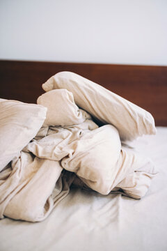 Crumpled Beige Bed Sheets on Mattress in Minimalist Room Setting