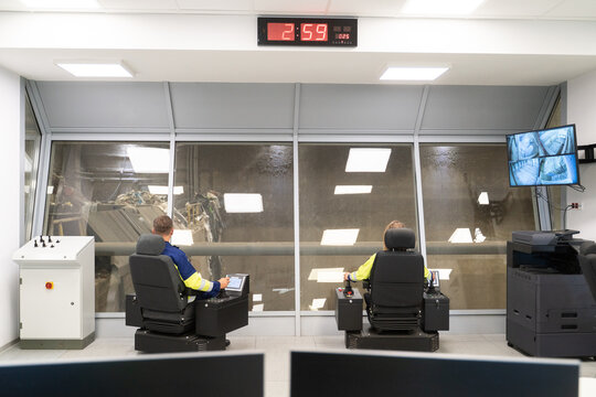 Control Room With Operators Monitoring Machinery 