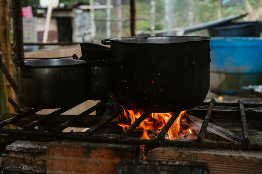 Sooty pots are warming on a wood fire in a rustic kitchen