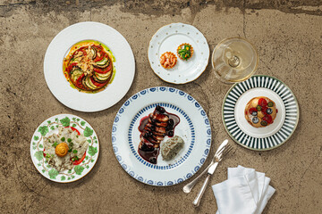 Assorted gourmet dishes and dessert on decorated plates