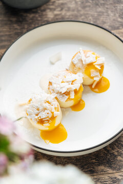 Mini pancakes with mango sauce and coconut flakes