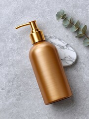 Luxurious golden bottle for soap rests on marble with eucalyptus branch.